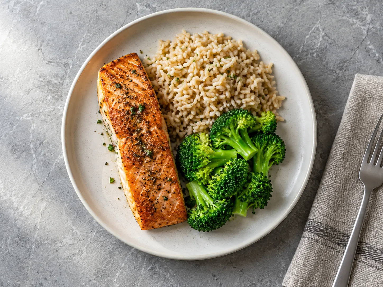Seared salmon with brown rice and broccoli on a stone table